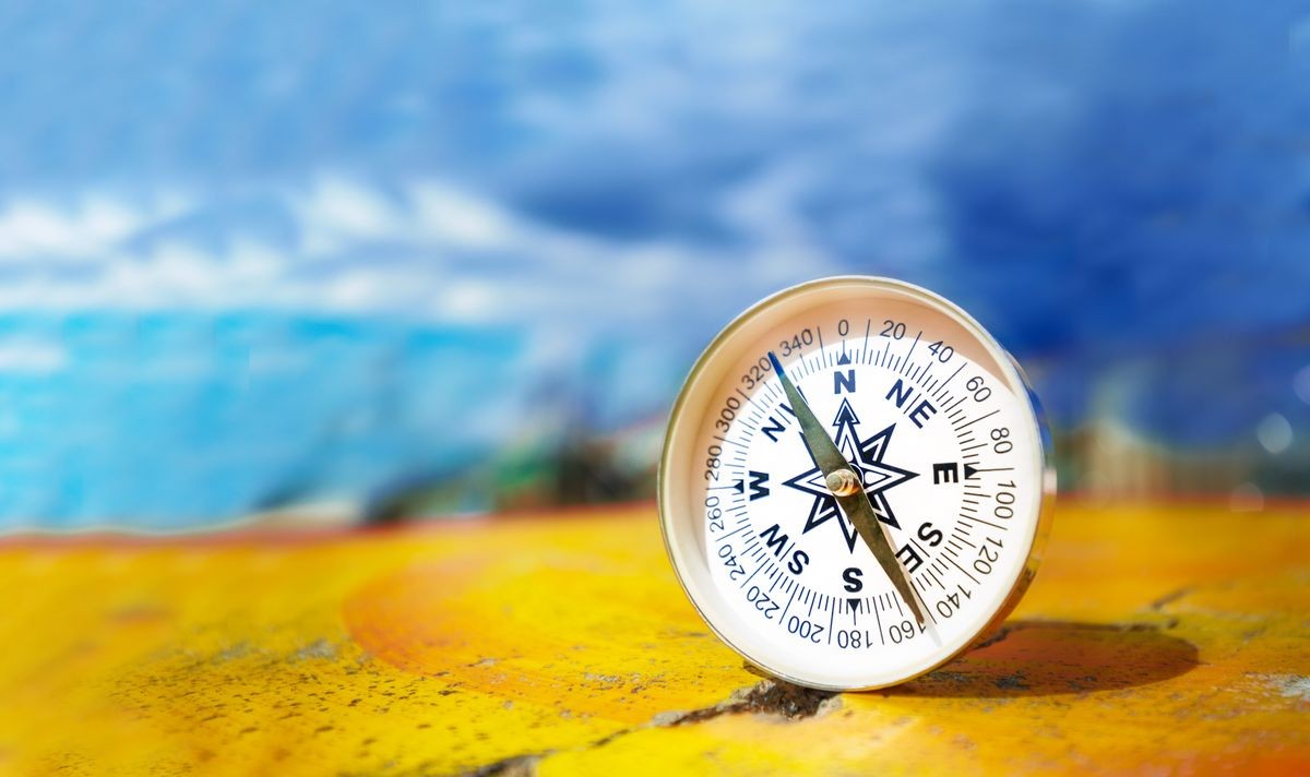 Compass on an old colorful table, travel and exploration concept